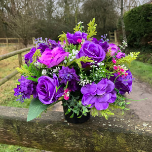 a silk graveside flower arrangement in black pot