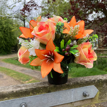 a grave pot with flowers featuring  artificial silk blooms