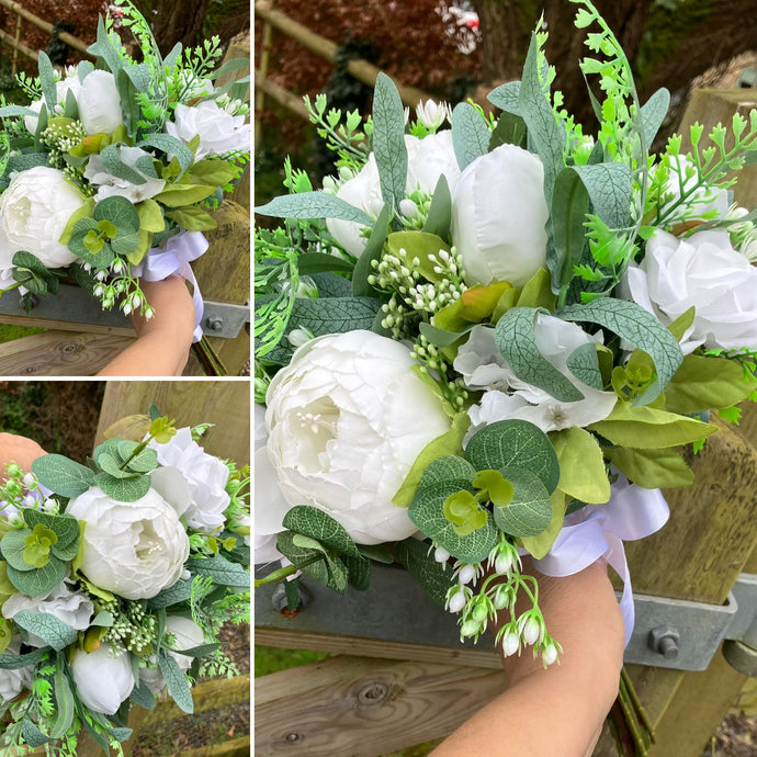 a large wedding bouquet of white roses and peonies