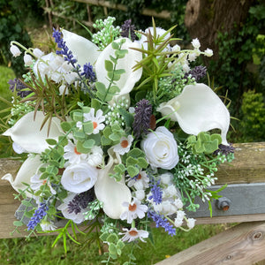 A brides bouquet of white calla, roses, lavender and foliage