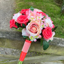 A brides bouquet featuring apricot, coral and peach roses & hydrangea