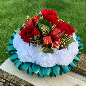 A christmas graveside memorial posy of red roses and carnations