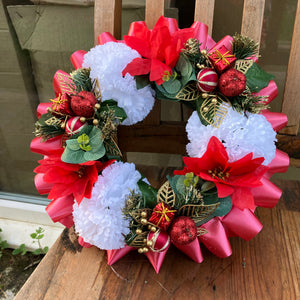 a memorial christmas wreath featuring parcels, carnations & poinsettia