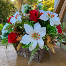 A Christmas artificial flower arrangement in rustic wooden container