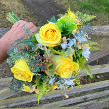 A brides bouquet of roses, peonies and fern