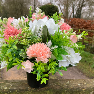 A graveside flower arrangement in black pot