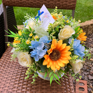 Sunflowers and blue hydrangea flowers in hat box