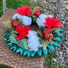 a memorial christmas wreath featuring baubles, cones and poinsettia