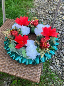 a memorial christmas wreath featuring baubles, cones and poinsettia
