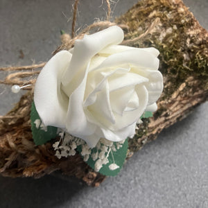 an artificial buttonhole featuring a single foam ivory rose