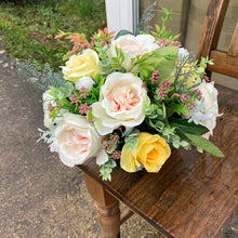 A vase arrangement of peonies & roses in ceramic vase