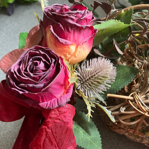 A wicker wreath with dried look flower arrangement