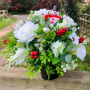 A Christmas graveside flower arrangement in black pot
