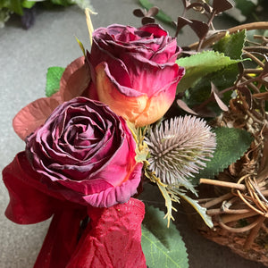 A wicker wreath with dried look flower arrangement