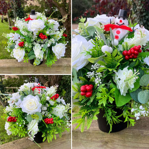 A Christmas graveside flower arrangement in black pot