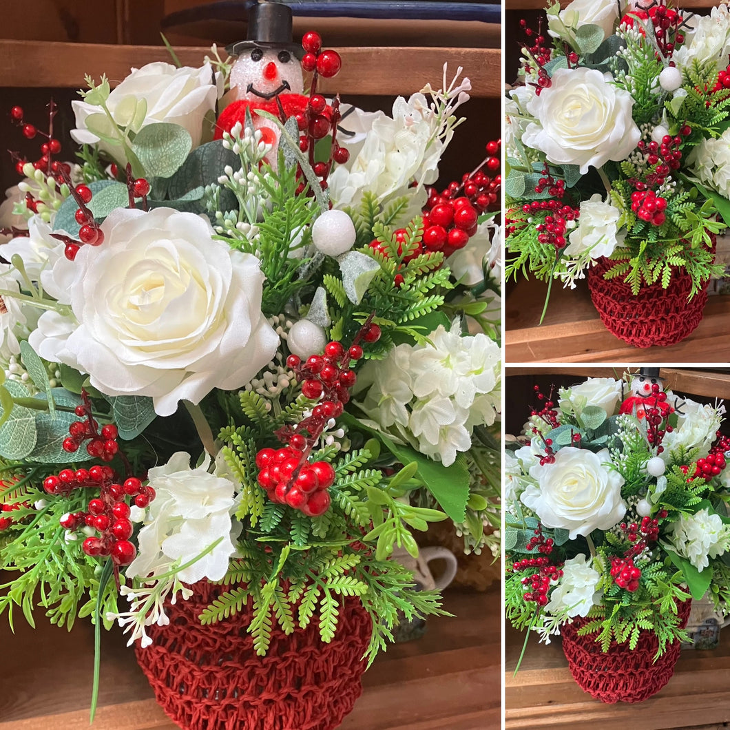 A Christmas flower arrangement in red knitted bag
