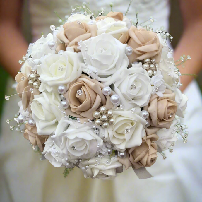 An artificial wedding bouquet featuring beige, white and ivory foam roses