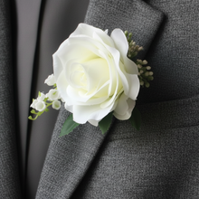 a buttonhole featuring lily of the valley & a white or ivory silk rose