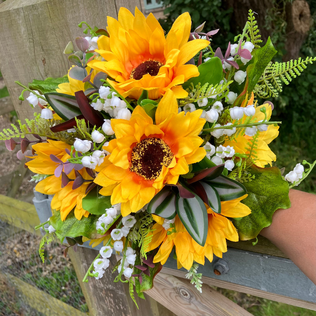 A wedding bouquet of artificial sunflowers and lily of the valley ...