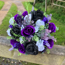 A bridal bouquet of white, black, purple artificial flowers