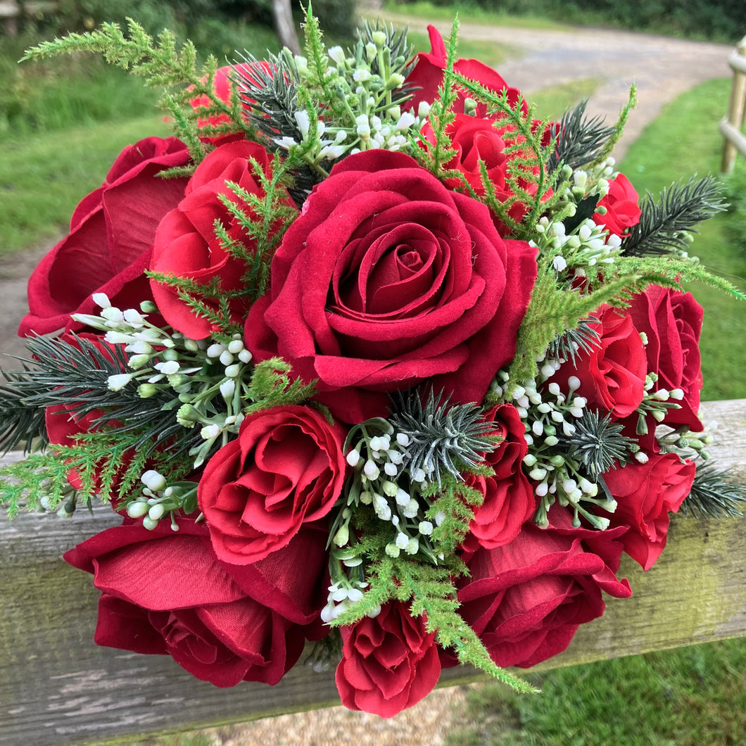 a brides bouquet of artificial silk red roses, waxflower and foliage