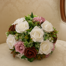 Bouquet of white, pink, and green flowers on a beige cushion