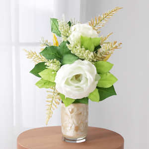 artificial white and gold Christmas flowers arrangement in glass bottle