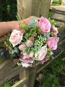 A bridal bouquet collection of dusky pink artificial silk roses and foliage