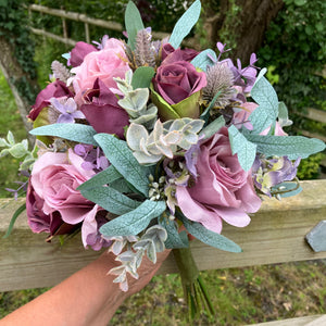 A wedding bouquet of artificial mauve/pink and burgundy roses