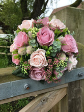 A bridal bouquet collection of dusky pink artificial silk roses and foliage