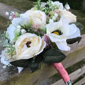 A brides bouquet of artificial cream ranunculus and anemone flowers