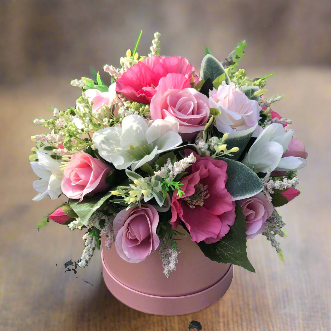 pearlescent hat box with large pink and white artificial flower arrangement