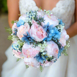 A wedding bouquet of pale pink and blue flowers