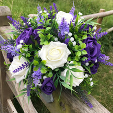 An artificial flower table centre in shades of ivory lilac & purple