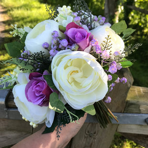 A brides bouquet of pink and lilac artificial silk flowers