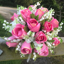 a brides wedding bouquet of artificial roses & lily of the valley