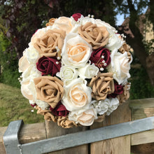 A wedding bouquet of champagne, ivory, burgundy & coffee foam roses
