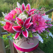 A flower arrangement in cream hat box