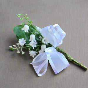 a buttonhole featuring artificial lily of the valley flowers