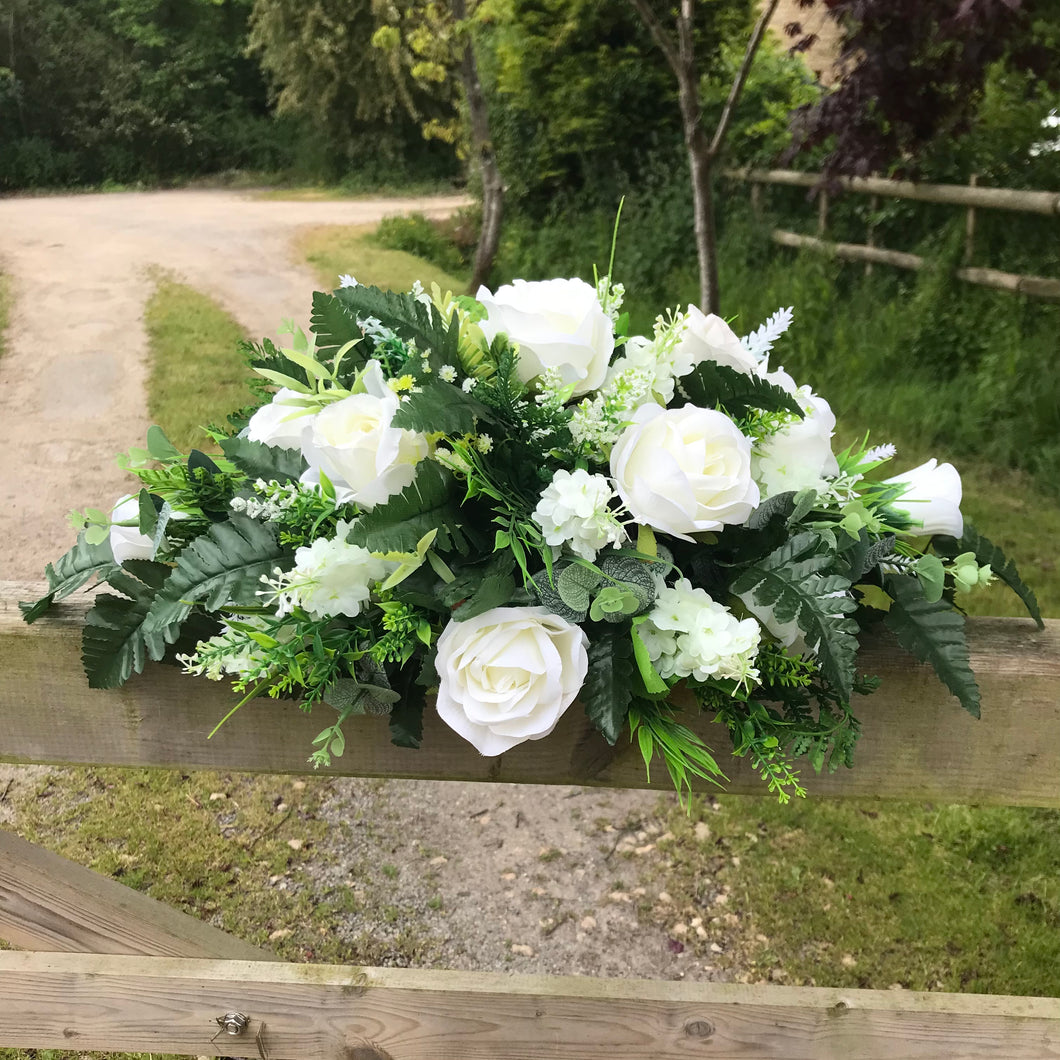 Top table flower arrangement featuring white or ivory roses