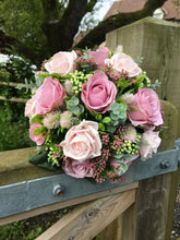 A bridal bouquet collection of dusky pink artificial silk roses and foliage