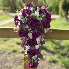 A collection of wedding bouquets featuring  artificial purple rose flowers & thistles