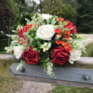 A flower arrangement of ivory orange and red flowers