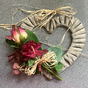 a rustic heart shaped wreath decorated with dried flowers