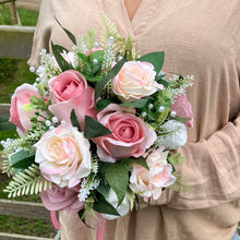 A teardrop bouquet of artificial pink and white roses