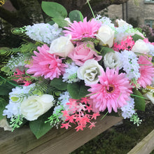 An artificial top table flower arrangement of pink and ivory roses and gerbera