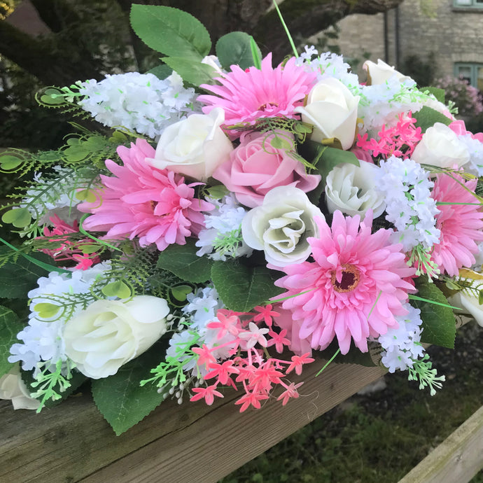 An artificial double ended flower arrangement of pink and ivory roses and gerbera