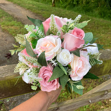 A teardrop bouquet of artificial pink and white roses