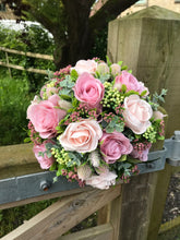 A bridal bouquet collection of dusky pink artificial silk roses and foliage