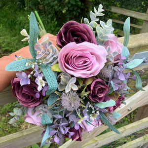 A wedding bouquet of artificial mauve/pink and burgundy roses